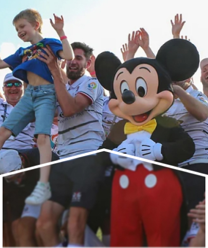 A group of people cheering next to a Mickey Mouse mascot.