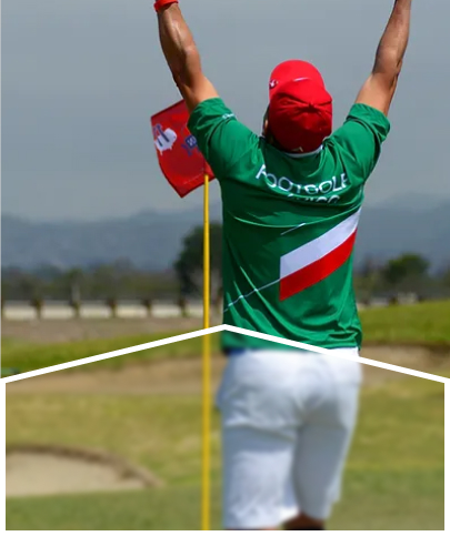 A man in green, red and white sportswear celebrating near the hole.