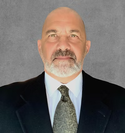 A portrait photo of a man in a dark suit wearing a tie.