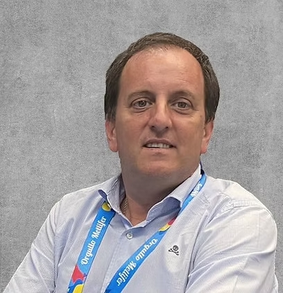 A man in a white shirt wearing a blue lanyard.